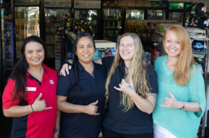 Four employees of Lahaina Petroleum giving shakas.